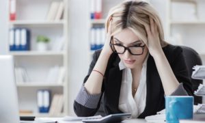 woman sitting at desk frustrated about her small business budget per channel