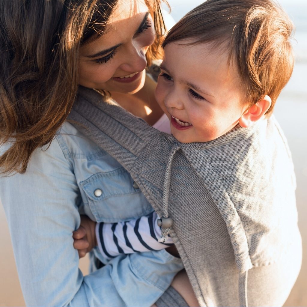 mother embracing her child wearing an organic cotton baby carrier from a sustainable and healthy baby and parent brand on loudbird digital marketing