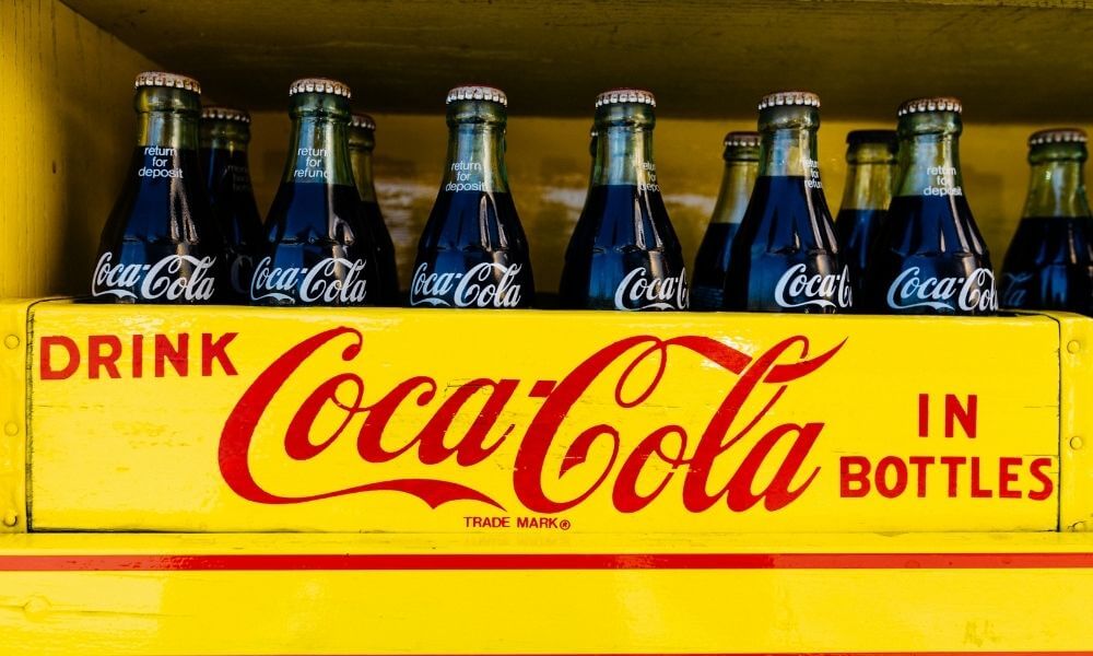 cocacola bottles in a colorful yellow crate types of brand names to help you name your business