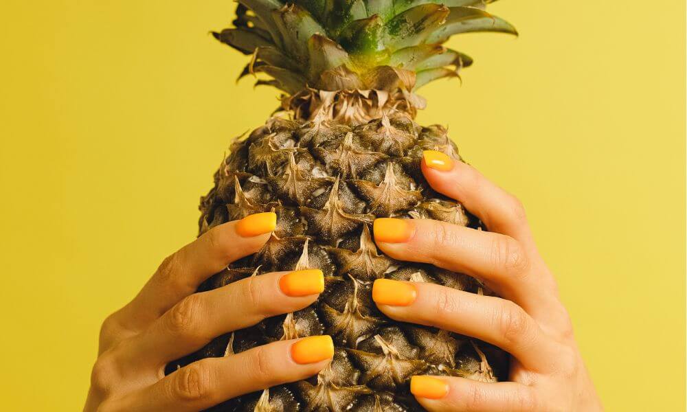 woman holding pineapple to represent health food marketing tips for small-batch brands